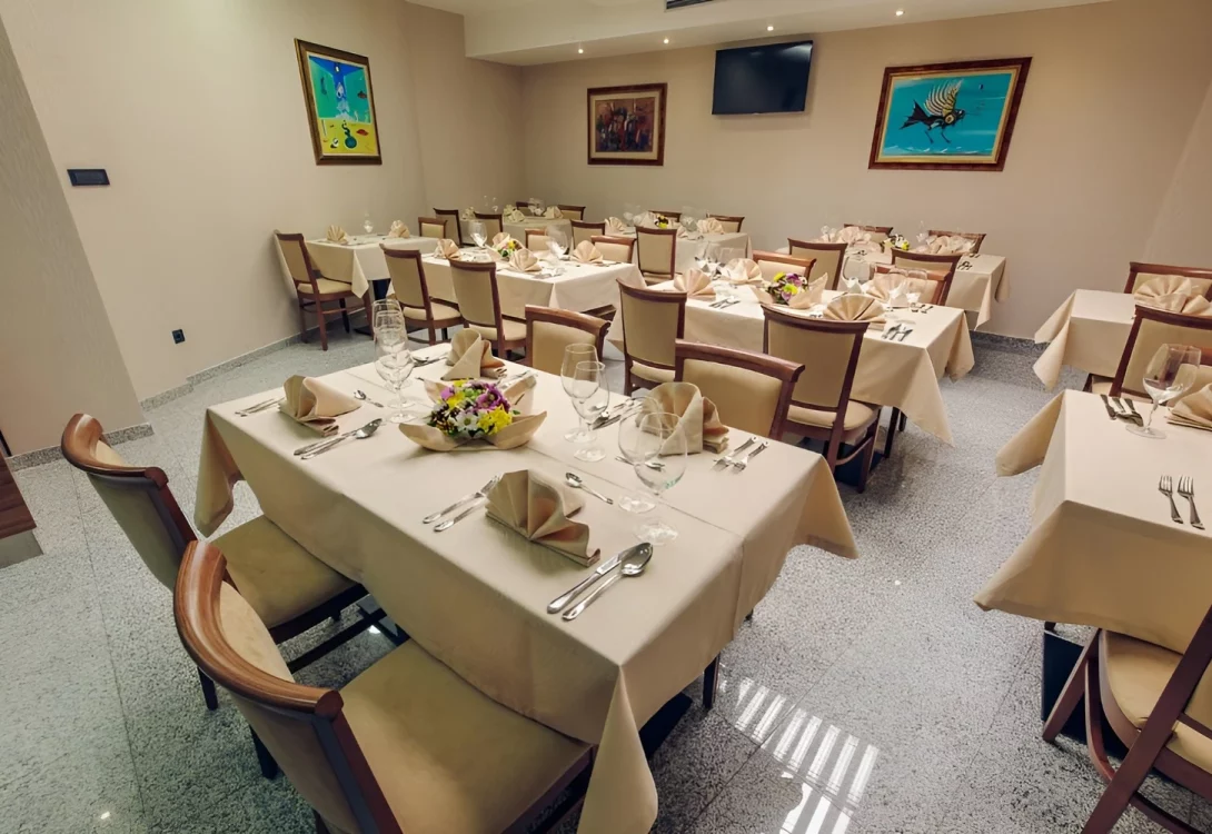 Restaurant Interior of the Kings Park Hotel in Montenegro with elegant table settings, floral centerpieces, and modern art decorations.