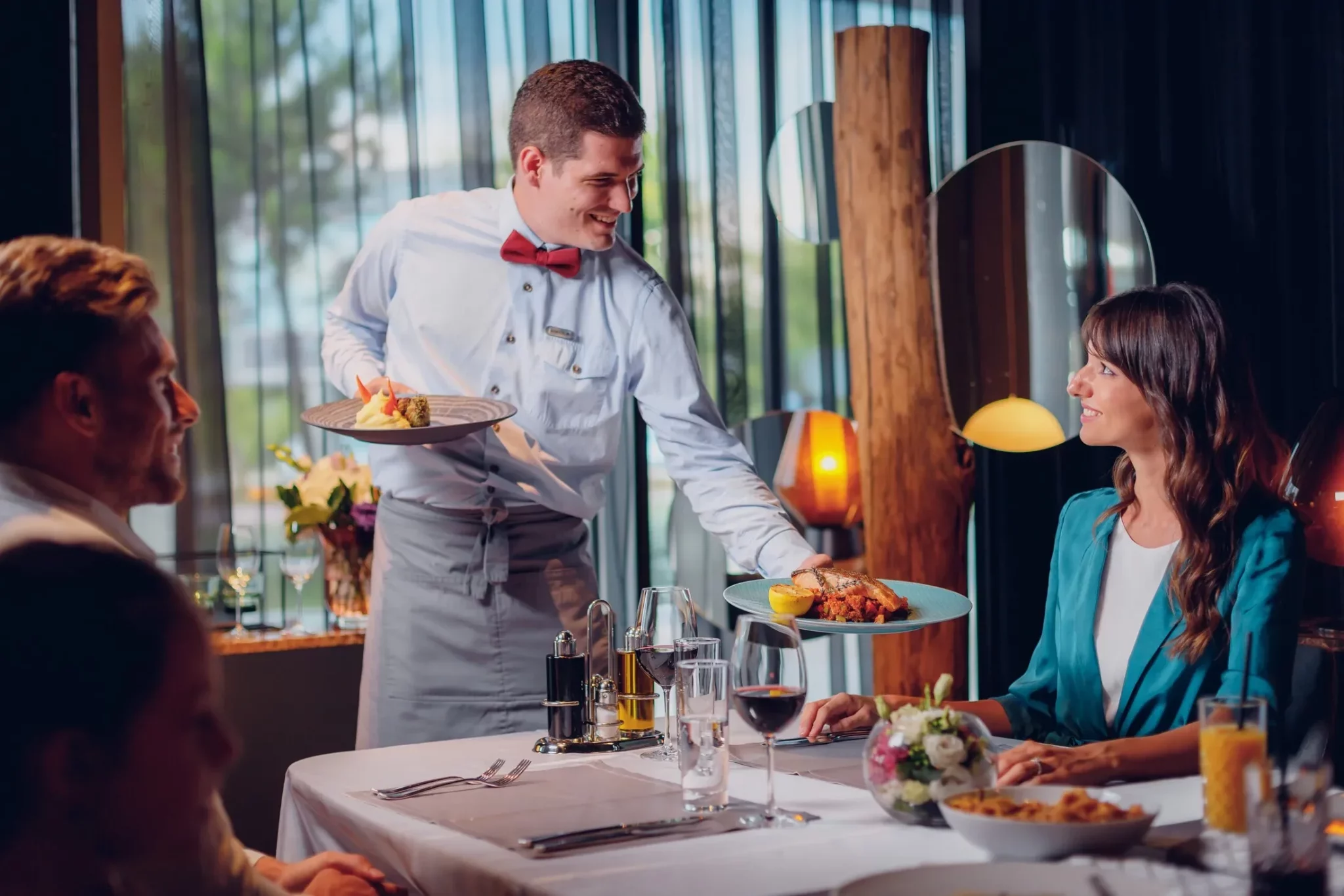 A waiter serving food to his guests