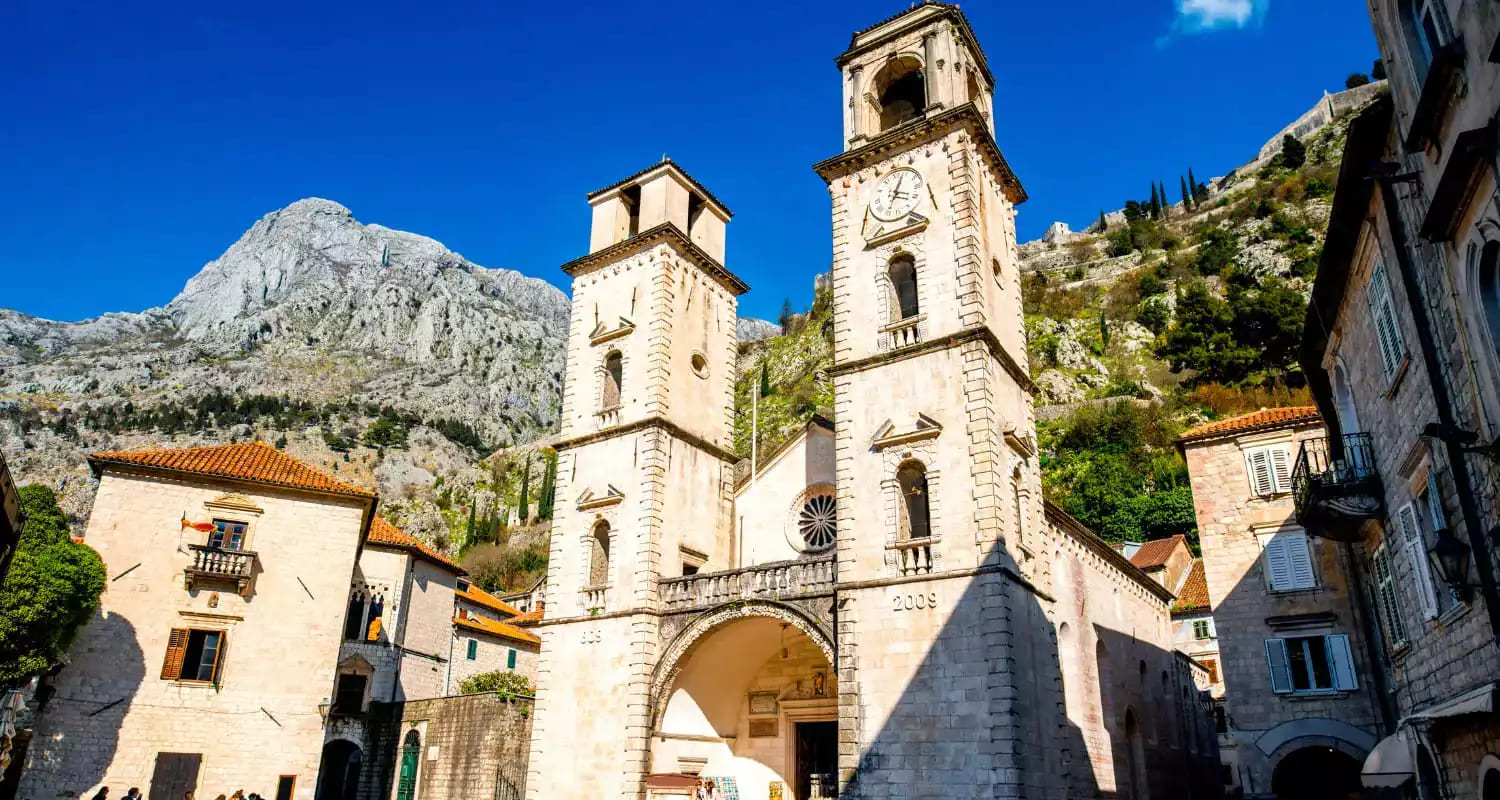 Close-up of Saint Tryphon Cathedral, a prominent Romanesque building in Kotor Old Town, Montenegro, with its distinctive twin bell towers.